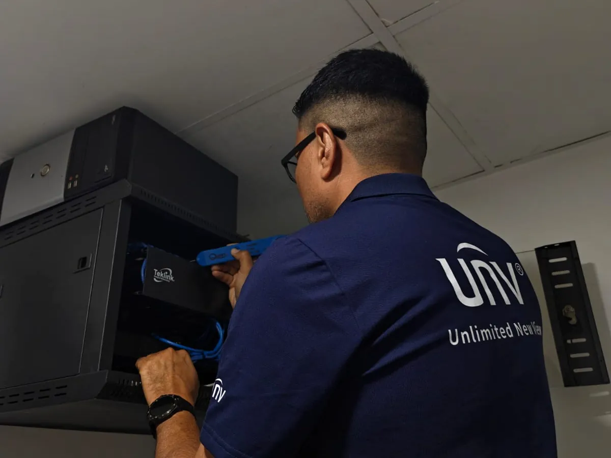 Técnico de Asistencia Informática trabajando en un gabinete de red
